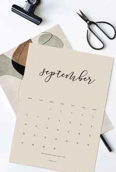 two calendars sitting on top of each other next to scissors and eyeglasses