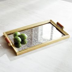 a mirror with some fruit on it and a pen sitting next to it, in front of a white table