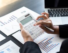 a person using a calculator on top of papers