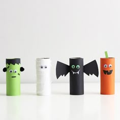 four toilet paper rolls decorated like halloween characters