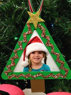 a green christmas tree ornament with a girl wearing a santa hat