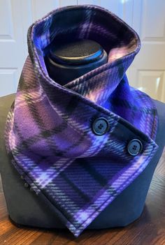 a purple and black plaid scarf on top of a wooden table