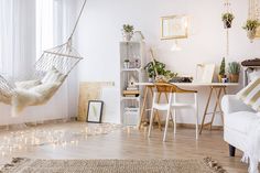 a living room with a hammock hanging from the ceiling and rug on the floor