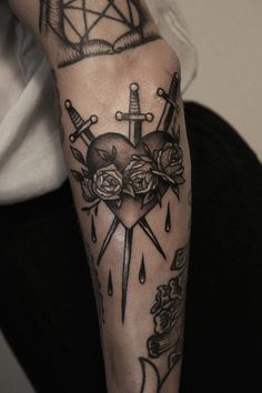 a person with a tattoo on their arm holding a knife and roses in front of them