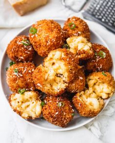 a white plate topped with meatballs covered in cheese and parmesan toppings