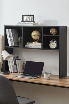 a laptop computer sitting on top of a wooden desk next to a book shelf filled with books