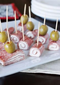 small appetizers with olives are arranged on a plate