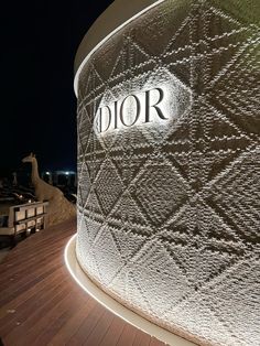 the entrance to dior is lit up at night with its logo on it's side