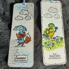 two bookmarks with cartoon characters on them, one is holding an umbrella and the other has