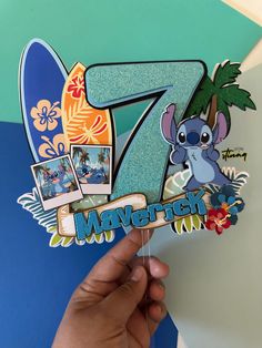 someone holding up a paper cutout with the number seven in front of them and some pictures on it