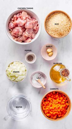 ingredients to make chicken broth laid out in bowls on a white marble counter top