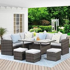 an outdoor patio with wicker furniture and blue pillows on the floor, surrounded by greenery