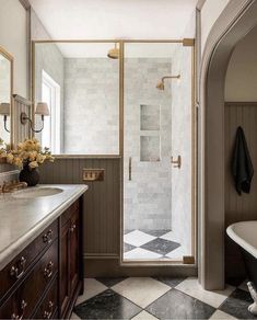 a bathroom with a checkered floor and marble counter tops, along with a walk in shower