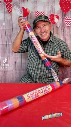 a man sitting at a table with a giant candy bar