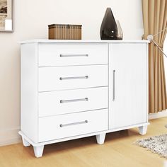 a white dresser with drawers and a lamp next to it on a hard wood floor