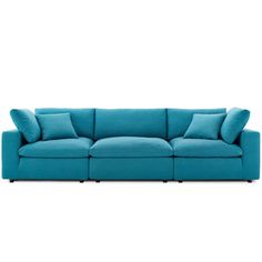 a large blue couch with pillows on it's back and arms, in front of a white background