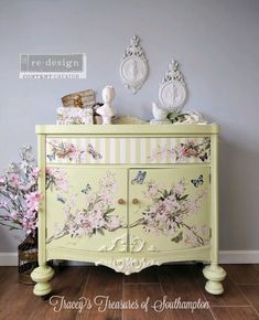 a yellow dresser with flowers painted on it