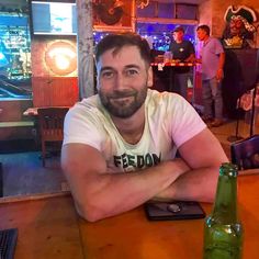 a man sitting at a bar with his arms crossed