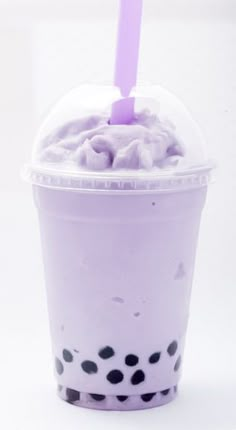 a purple drink in a plastic cup with polka dots and a straw sticking out of it