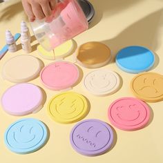 a child is painting smiley faces on the table