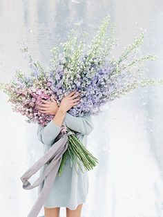 a woman holding a bouquet of flowers in her hands