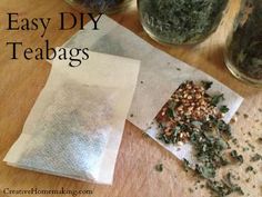 tea bags are sitting on a table next to some dried herbs and other things in glass jars