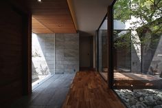 an empty room with wood flooring and large windows on the side of the house