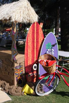 several surfboards and bicycles are on display in the grass