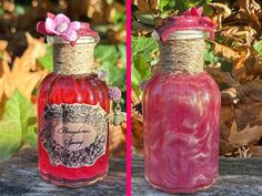 two jars with flowers in them sitting on a table next to leaves and plants, one is red and the other is pink