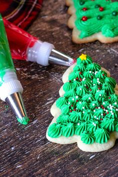 decorated cookies with icing and decorations on a wooden table next to a bottle of glue