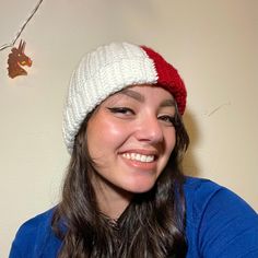 a smiling woman wearing a red and white knitted hat