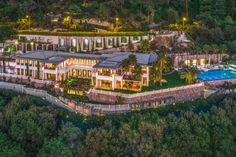 an aerial view of a large mansion in the middle of trees and water at night