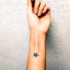 a woman's arm with a small star tattoo on the left side of her wrist