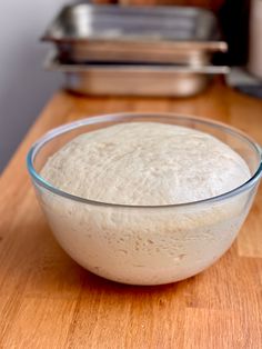 a bowl filled with batter sitting on top of a wooden table