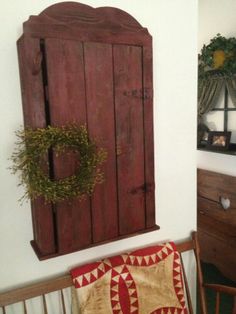 a wooden cabinet with a wreath hanging on it's side