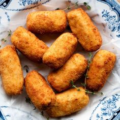 fried chicken nuggets on a blue and white plate with sprigs of rosemary