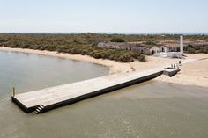 a long wooden dock sitting on top of a sandy beach