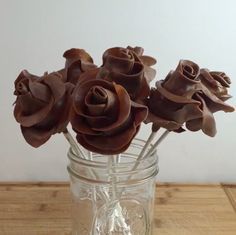 chocolate flowers in a glass jar on a wooden table