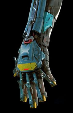 a robotic hand is holding something in it's right hand, with yellow and blue accents