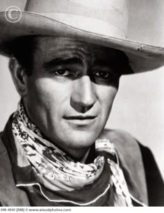 black and white photograph of a man wearing a cowboy hat, scarf and bandana