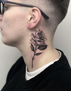 a woman's neck with a rose tattoo on her left side behind the ear