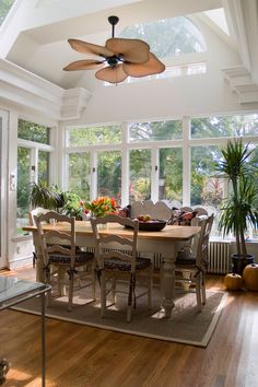 a dining room table with chairs and a ceiling fan