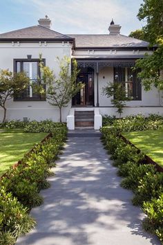 a white house with black shutters and trees