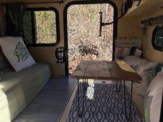 the inside of a camper with a table and couch