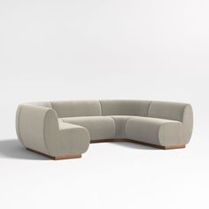 a curved sectional sofa with wooden feet and arms in grey fabric, viewed from the front