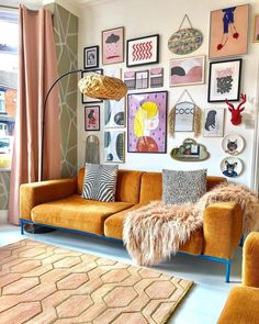 a living room filled with lots of pictures on the wall and furniture in front of it