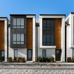 two story white and brown apartment building with steps leading up to it