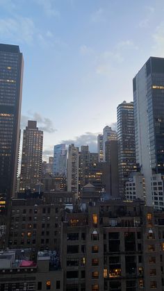 the city skyline is lit up at night, with skyscrapers in the foreground