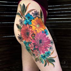 a woman's thigh with colorful flowers on it