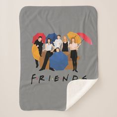 the friends are holding umbrellas in front of them on a gray and white blanket